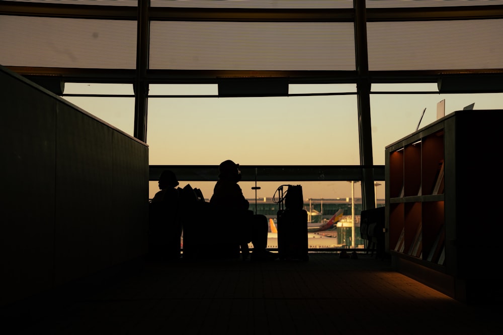 a silhouette of a person sitting in an airport