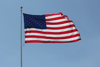 An American flag waving proudly against a clear blue sky.