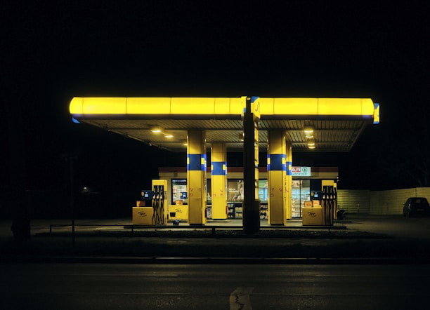 a gas station lit up at night time