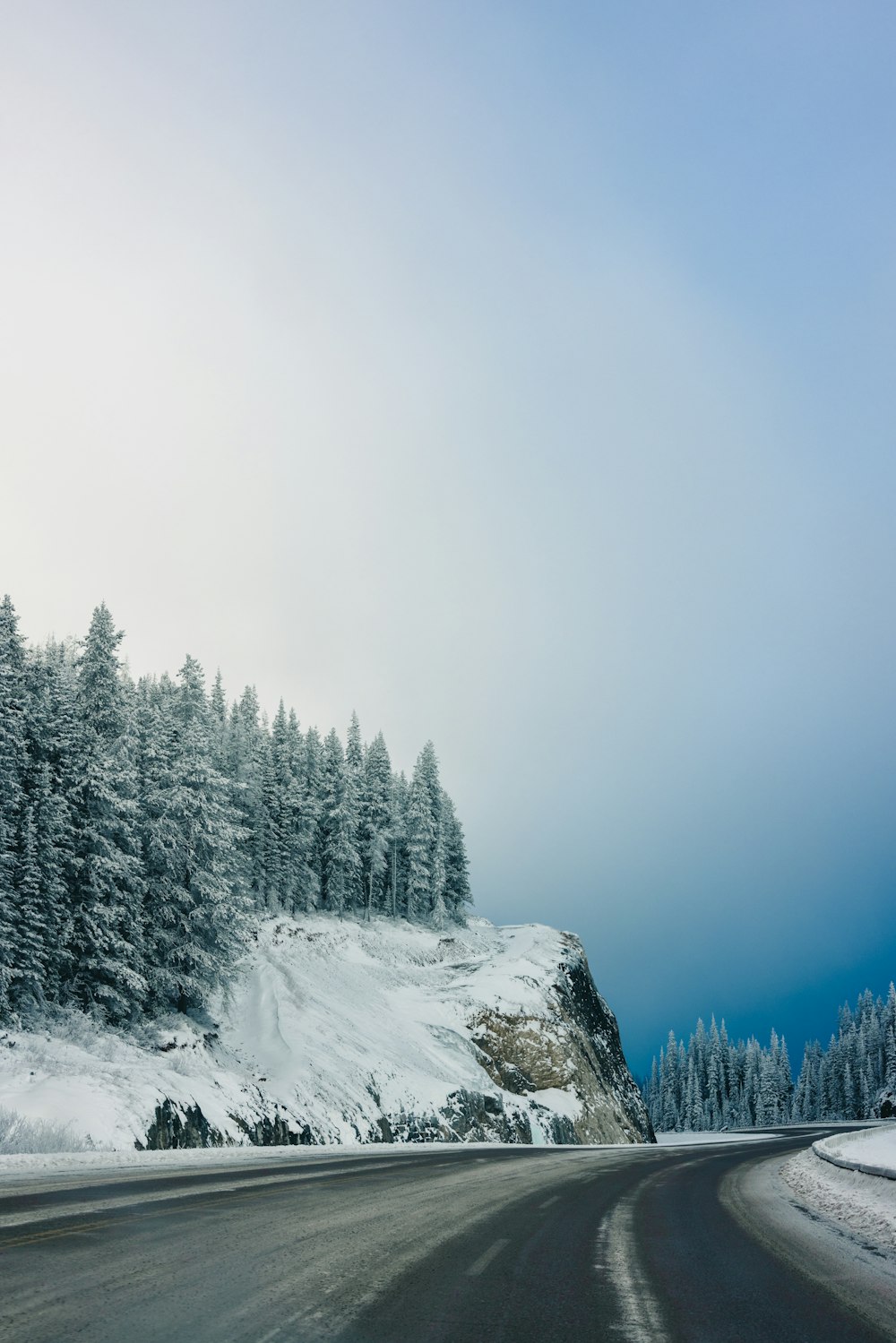 a snow covered mountain with a road going through it