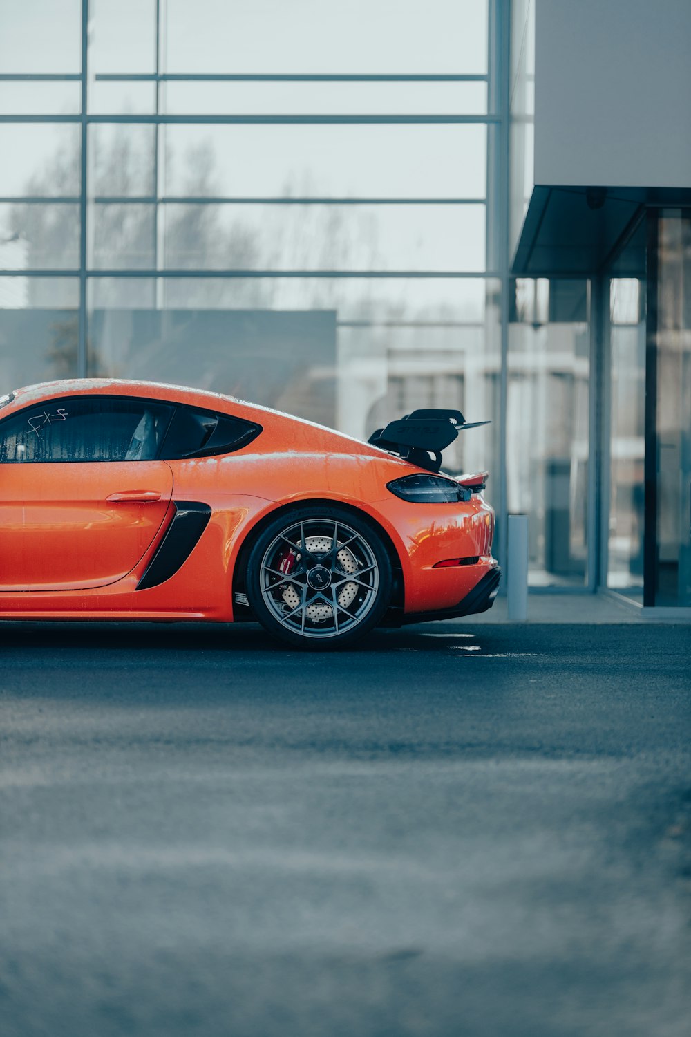 an orange sports car parked in front of a building