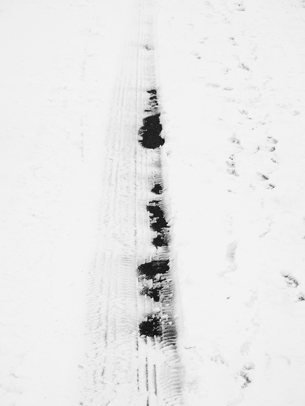 a snow covered road with a line of cars on it