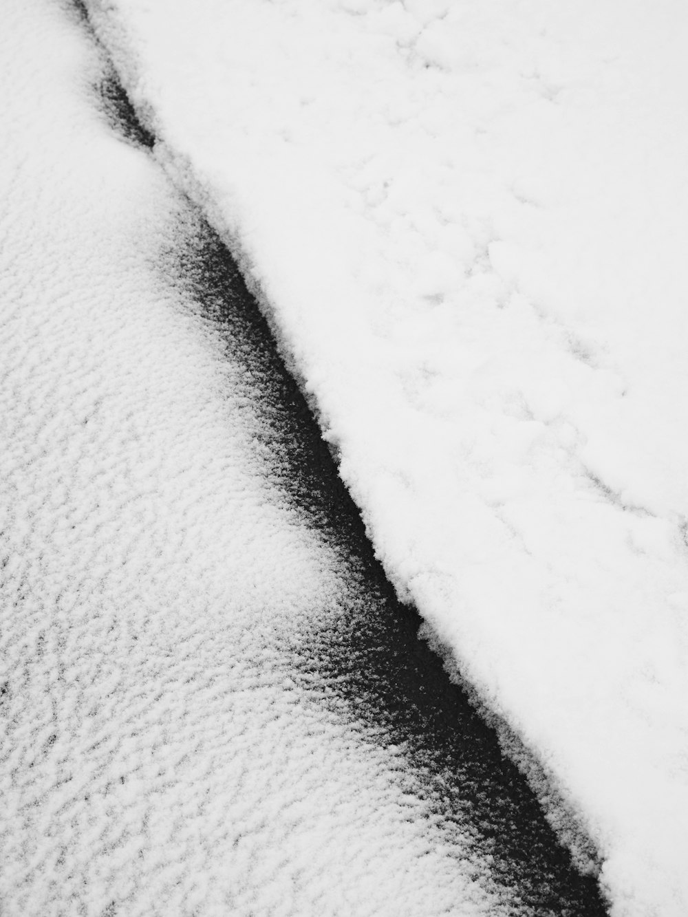 a black and white photo of snow and water