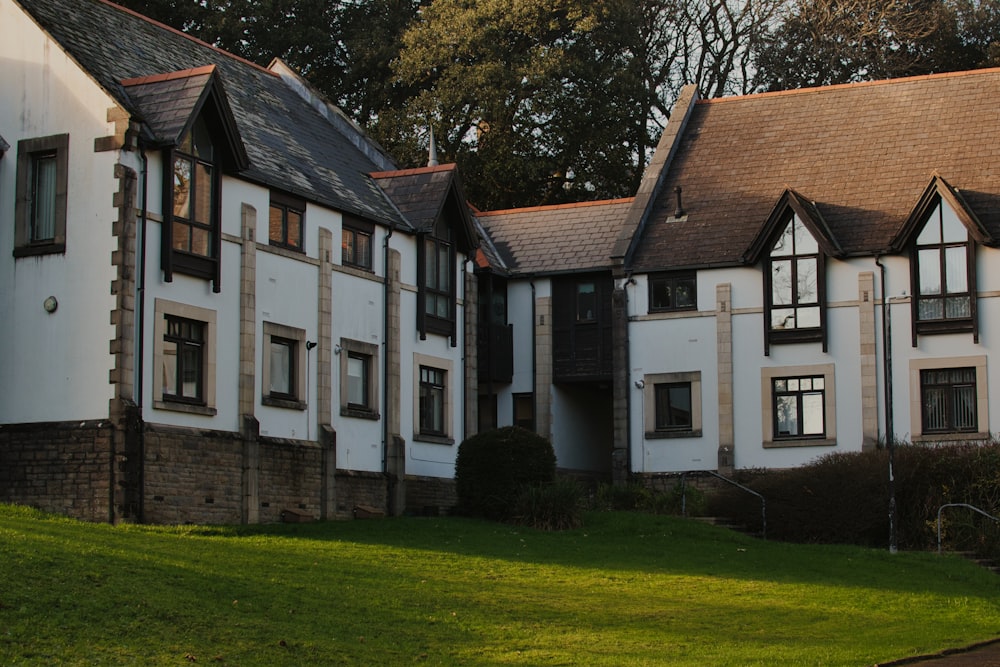 a large white building sitting on top of a lush green field