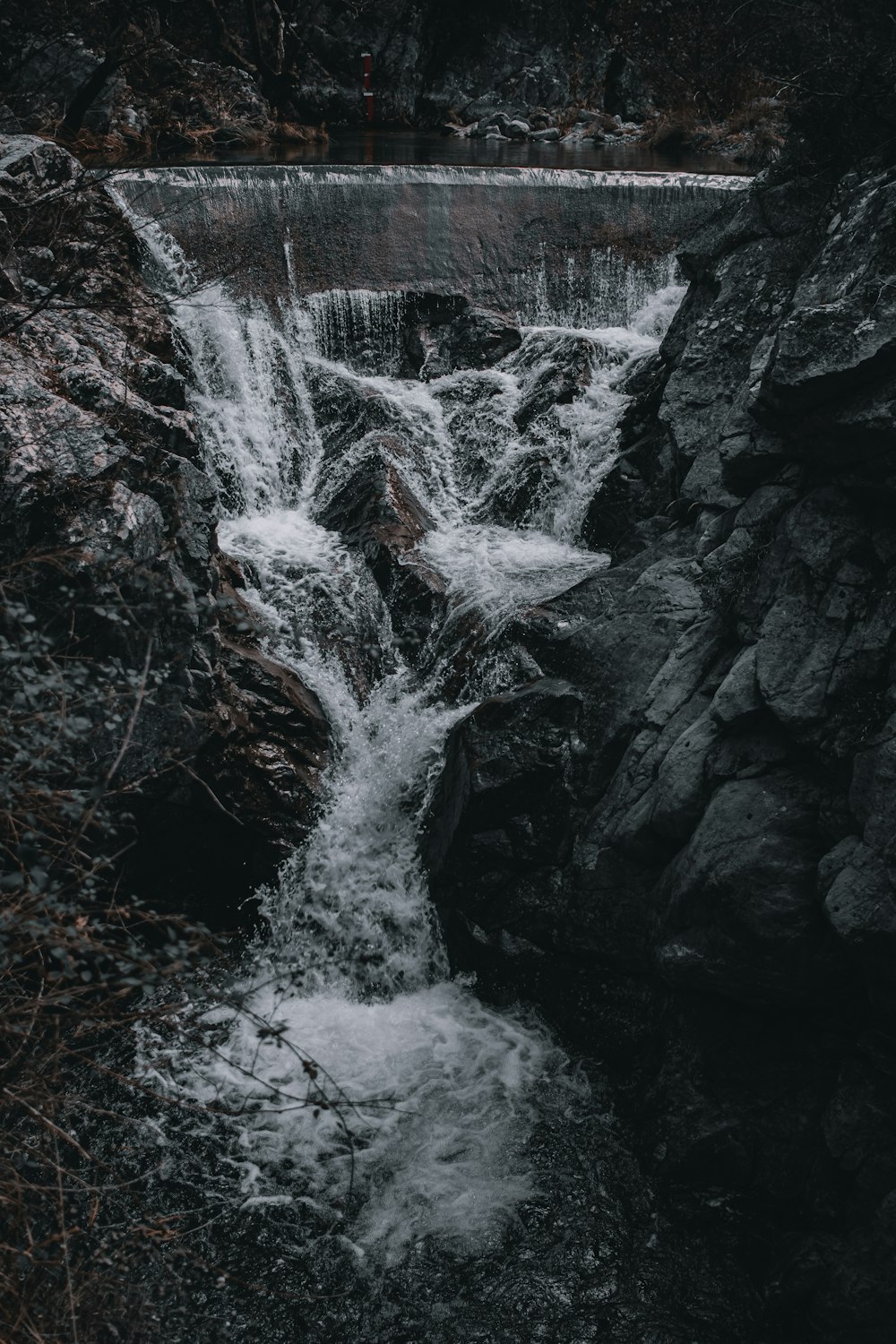 a small waterfall in the middle of a forest