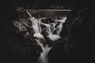 a black and white photo of a waterfall