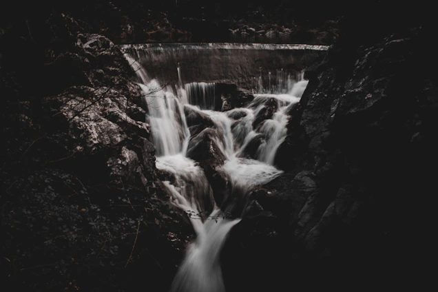 a black and white photo of a waterfall