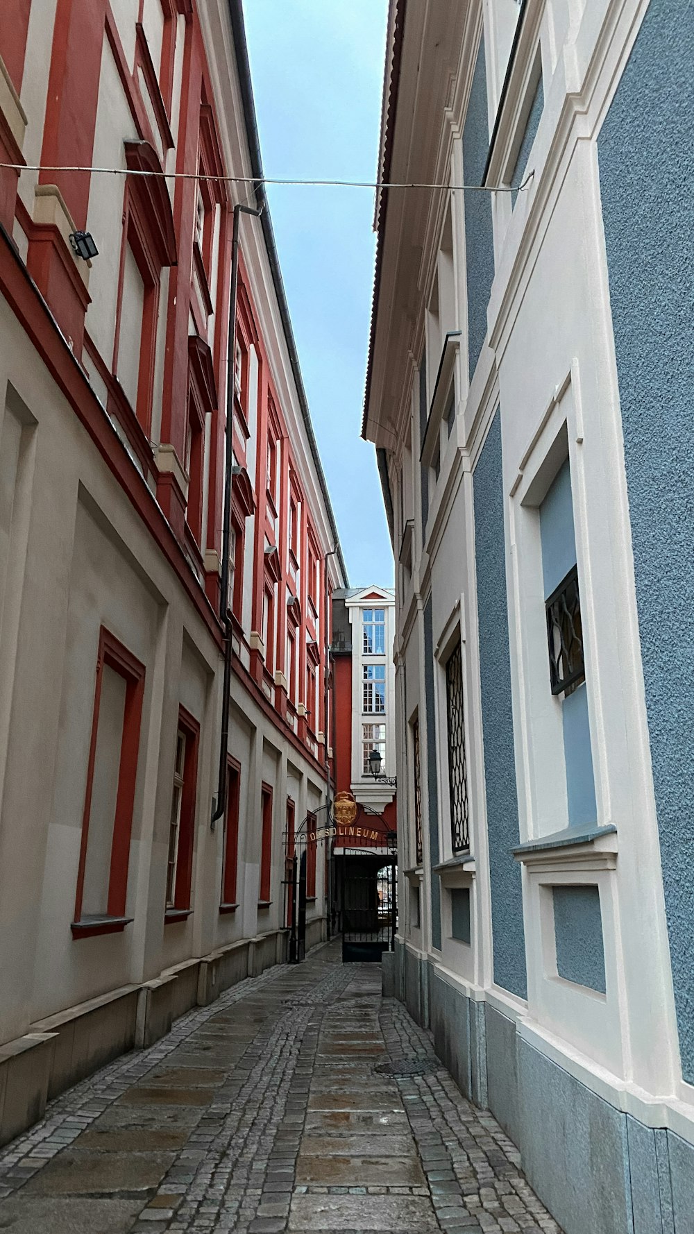a cobblestone street lined with red and white buildings