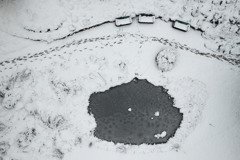 a snow covered ground with a hole in the middle of it