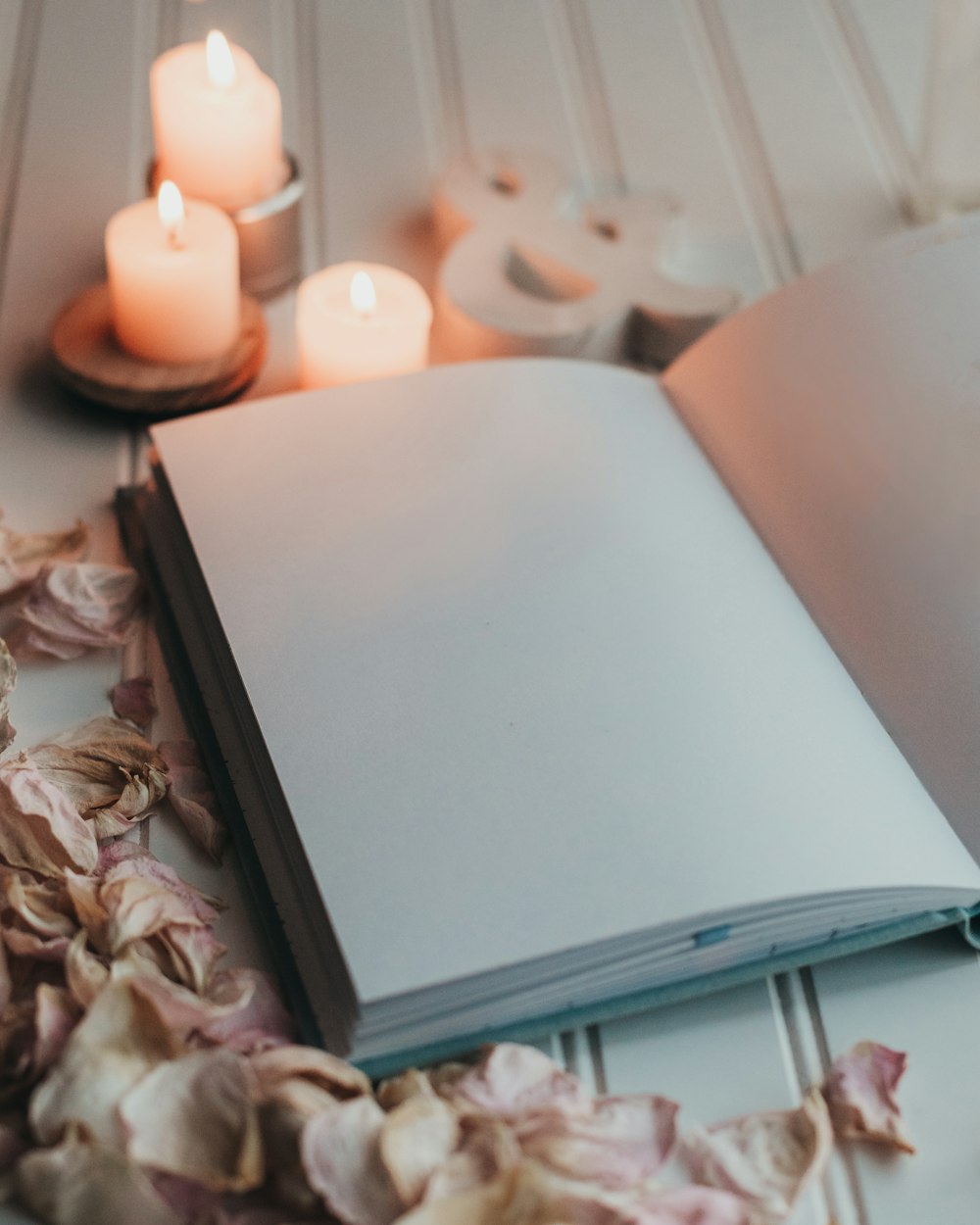 an open book sitting on top of a table next to candles