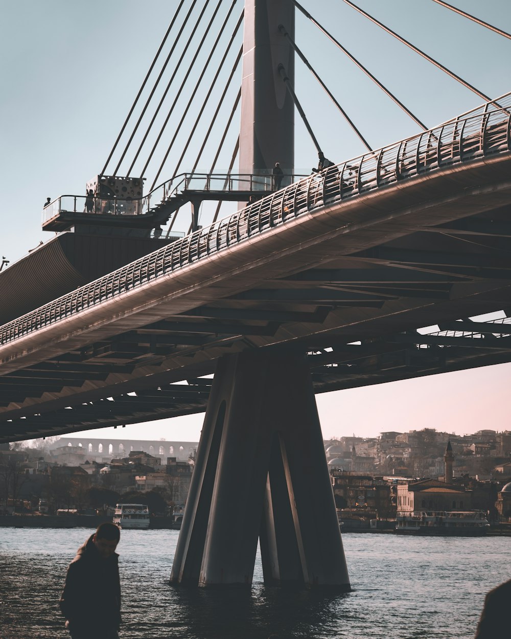 a man standing on the side of a bridge next to a body of water