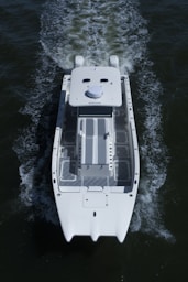 a small white boat traveling across a body of water