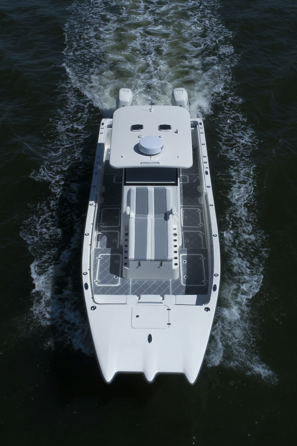 a small white boat traveling across a body of water