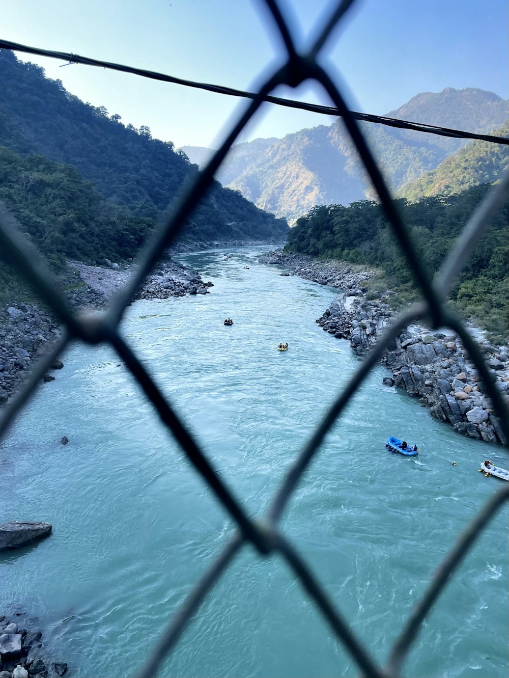 a view of a river through a chain link fence