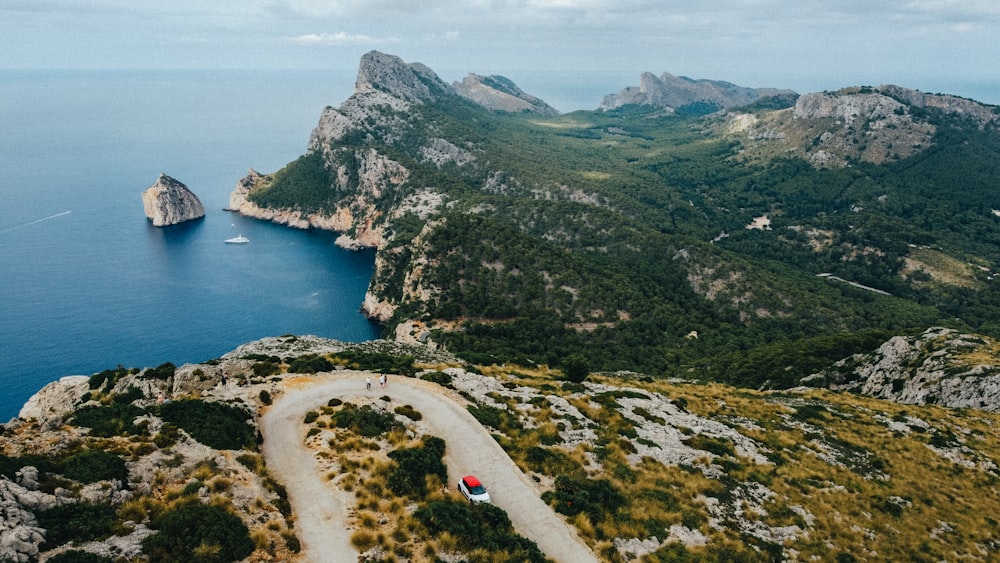 a car driving down a road near a mountain