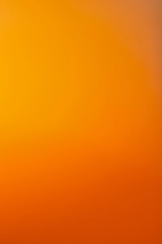 an airplane flying in the sky at sunset