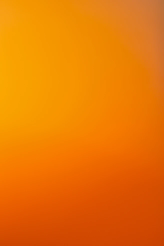 an airplane flying in the sky at sunset