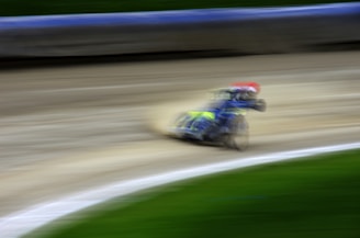 A dynamic shot of a motorcycle racing on a track, dust and motion blur emphasizing speed.