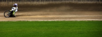 Close-up of a rider crossing the finish line with dirt flying behind.
