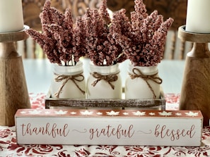 a couple of jars filled with flowers on top of a table