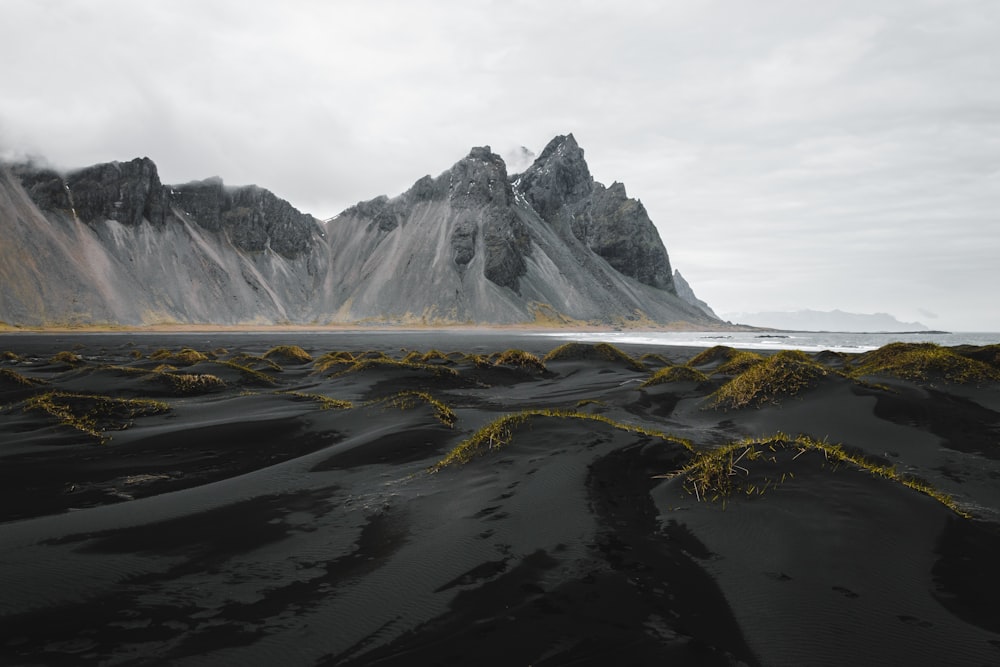 a black sand beach with a mountain in the background