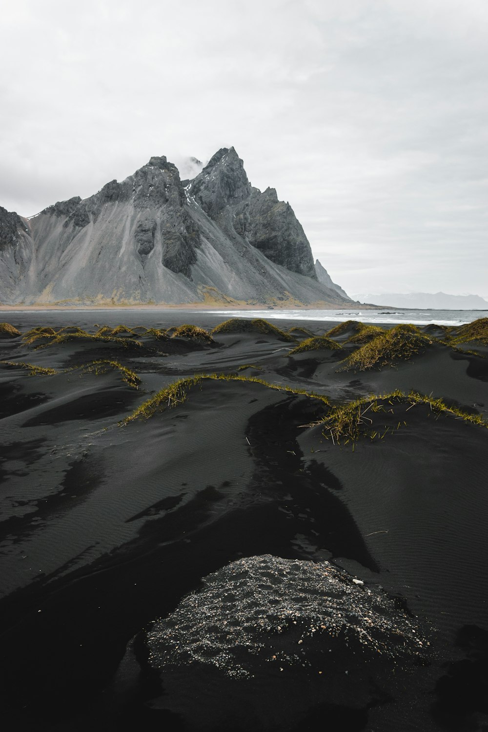 a black sand beach with a mountain in the background