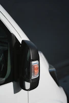 Side mirror with a turn signal indicator, highlighting the fine detailing and good condition despite being pre-owned.