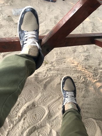 Close-up of a pair of casual espadrilles resting on a sunlit wooden bench outdoors.
