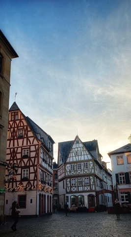 A serene European village with cobblestone streets and historic stone houses under a clear blue sky.