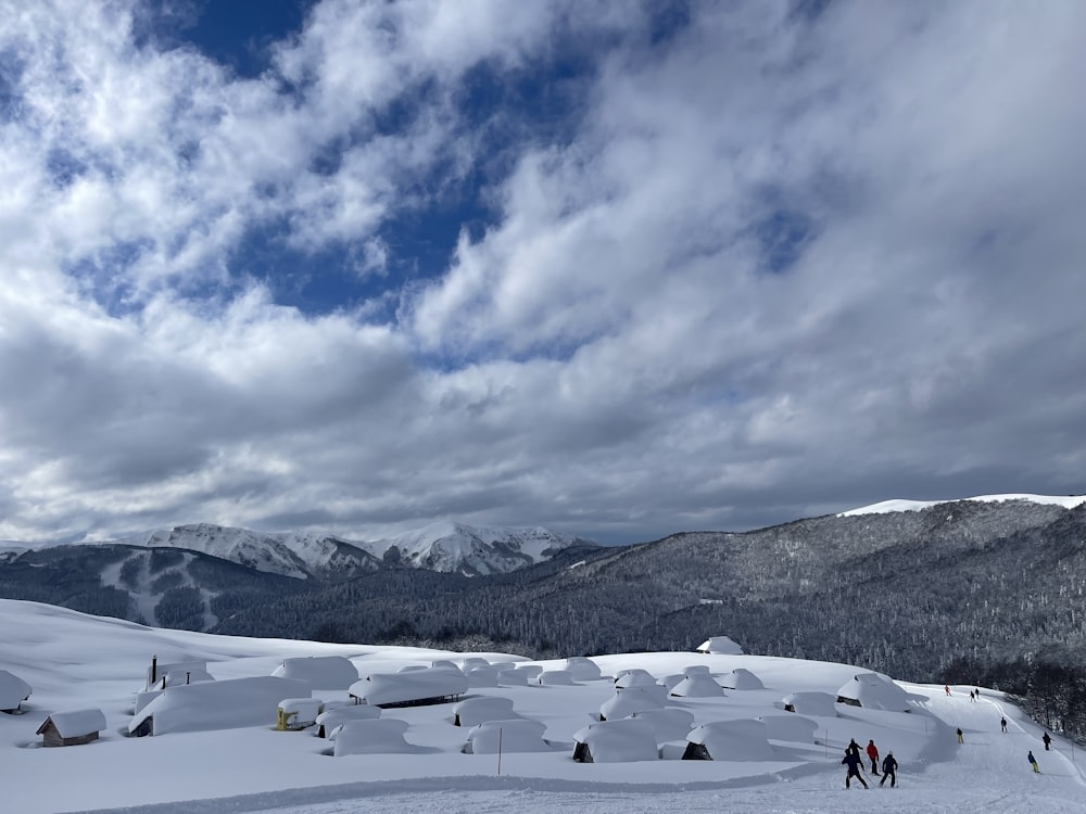 a group of people standing on top of a snow covered slope