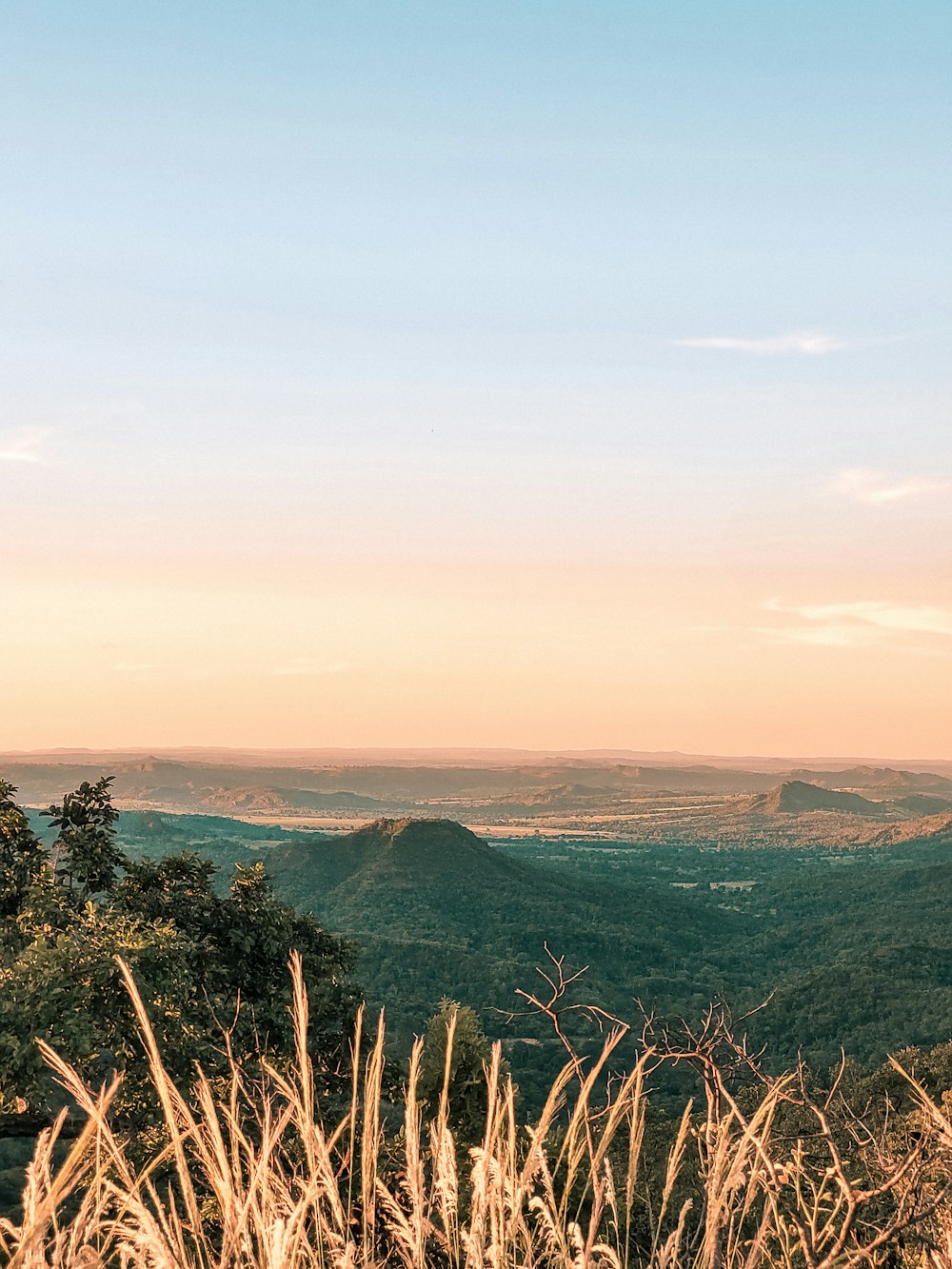 a view of a valley and mountains from the top of a hill