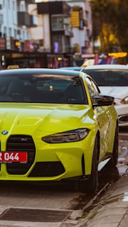 A stylish green luxury car shining under bright city lights.