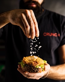 a man is sprinkling seeds on a sandwich