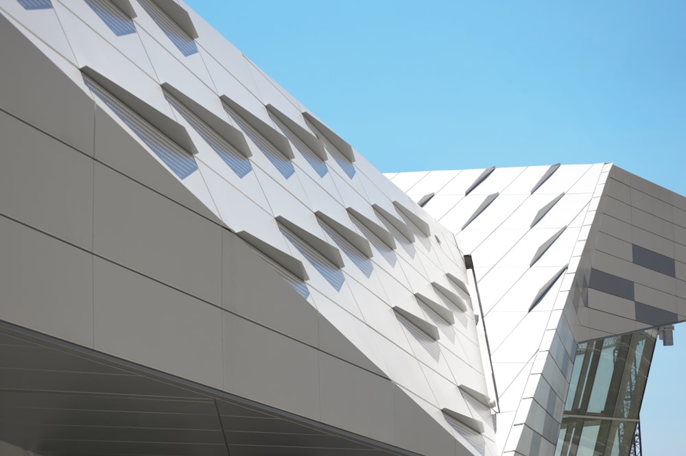 a white building with a curved roof and a sky background