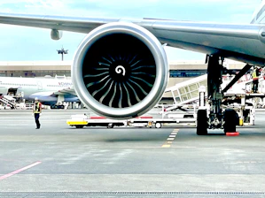 Close-up of ground support equipment being inspected at a busy airport apron.