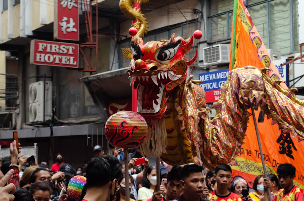 a group of people standing around a dragon float