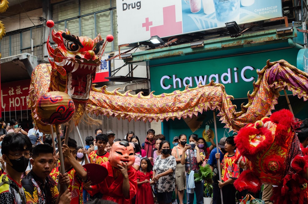 a group of people standing around a dragon float
