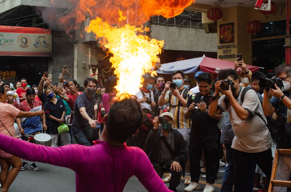 a crowd of people standing around a fire pit