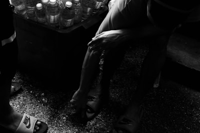 A tired parent struggling to lift a heavy water jug at home.