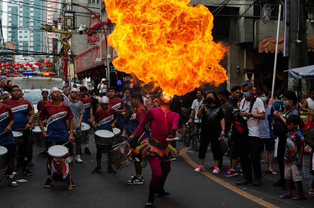 a group of people walking down a street with fire in the air