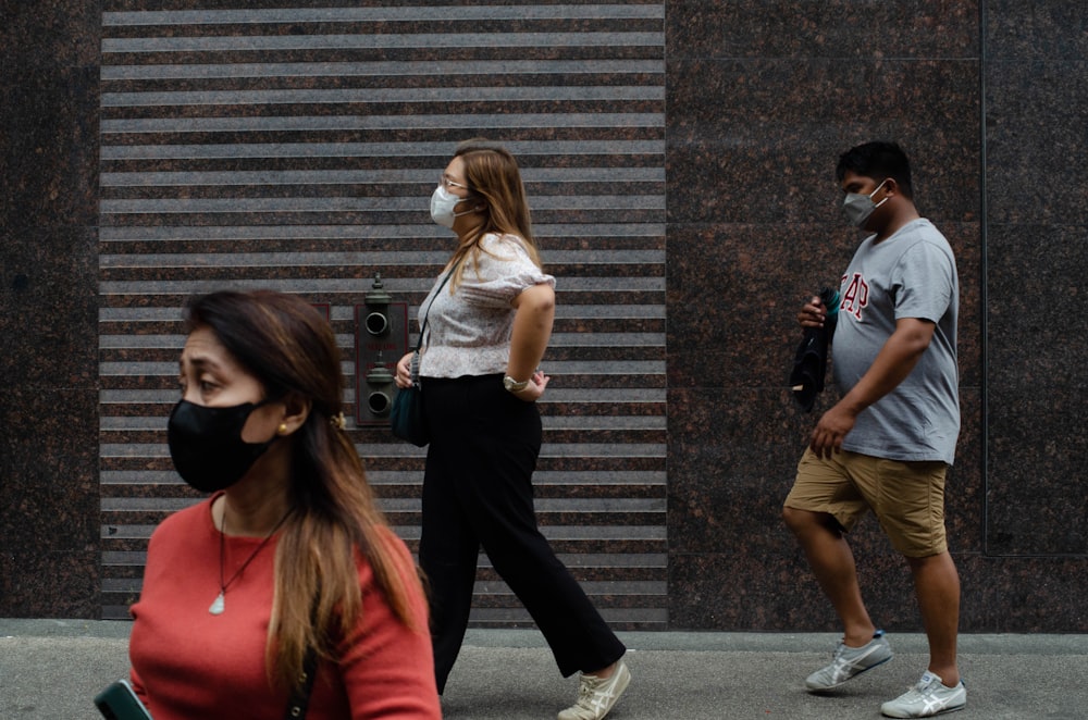 a woman wearing a face mask walking down a street