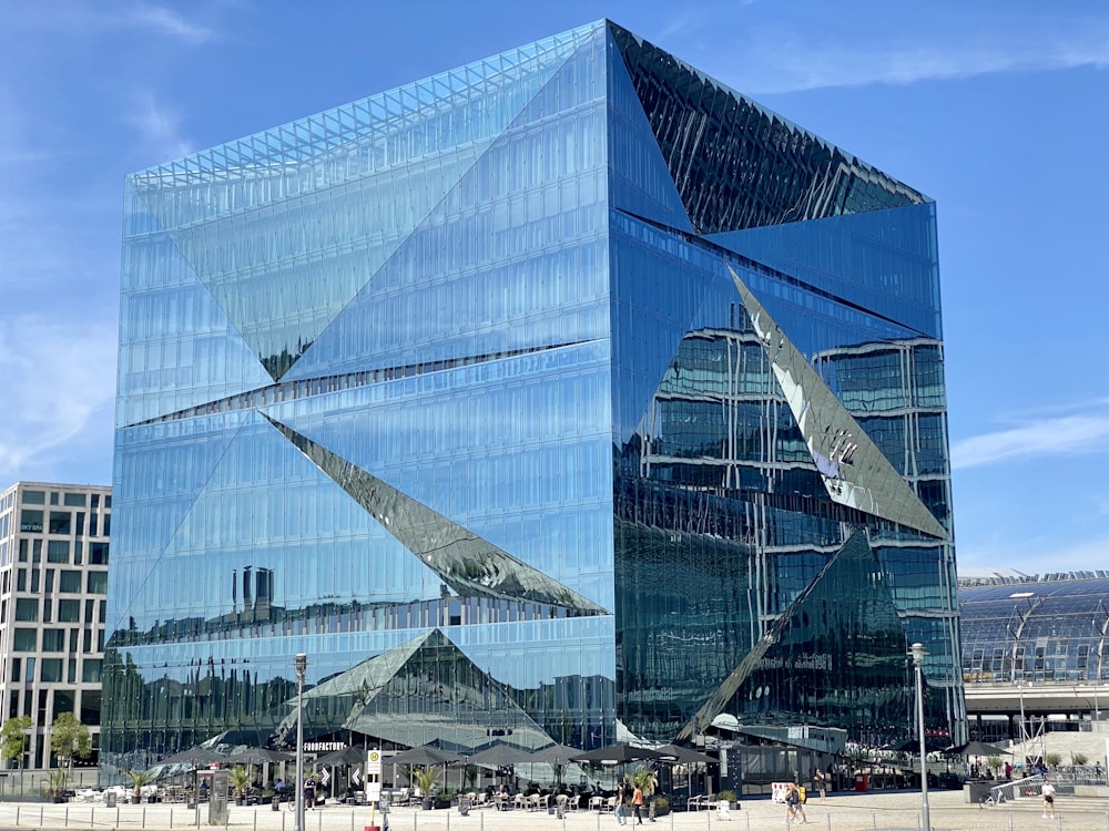 a large glass building with people walking in front of it
