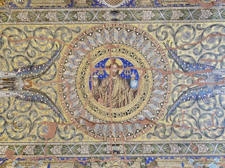 An intricate mosaic blending symbols from Greek, Georgian, Romanian, and Scandinavian mythologies, glowing softly against a dark background.