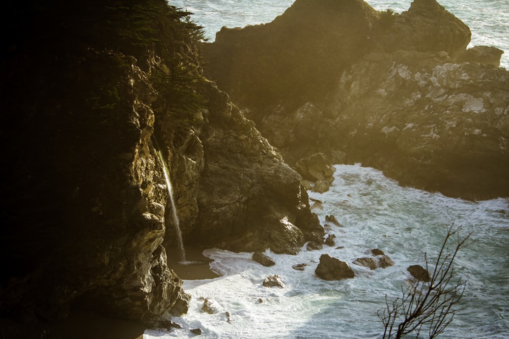 a large body of water next to a rocky cliff