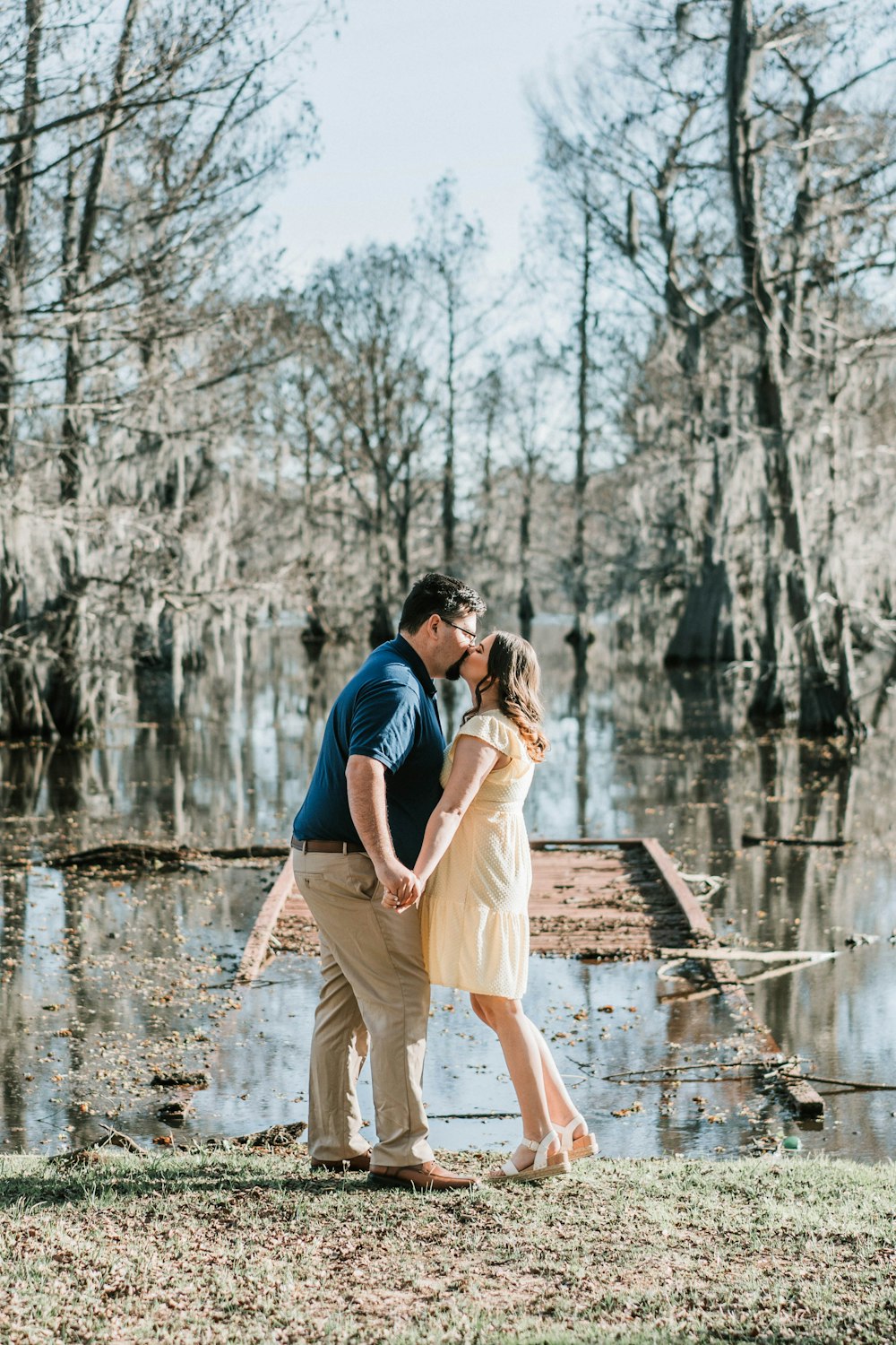 a man and a woman standing next to a body of water