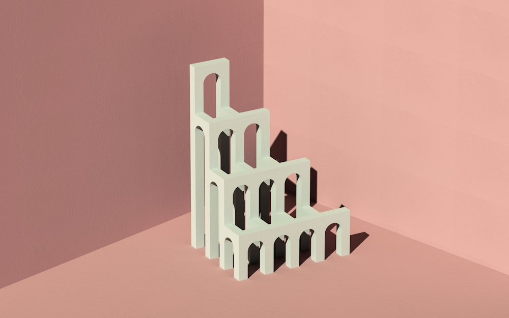 a white sculpture sitting on top of a pink wall