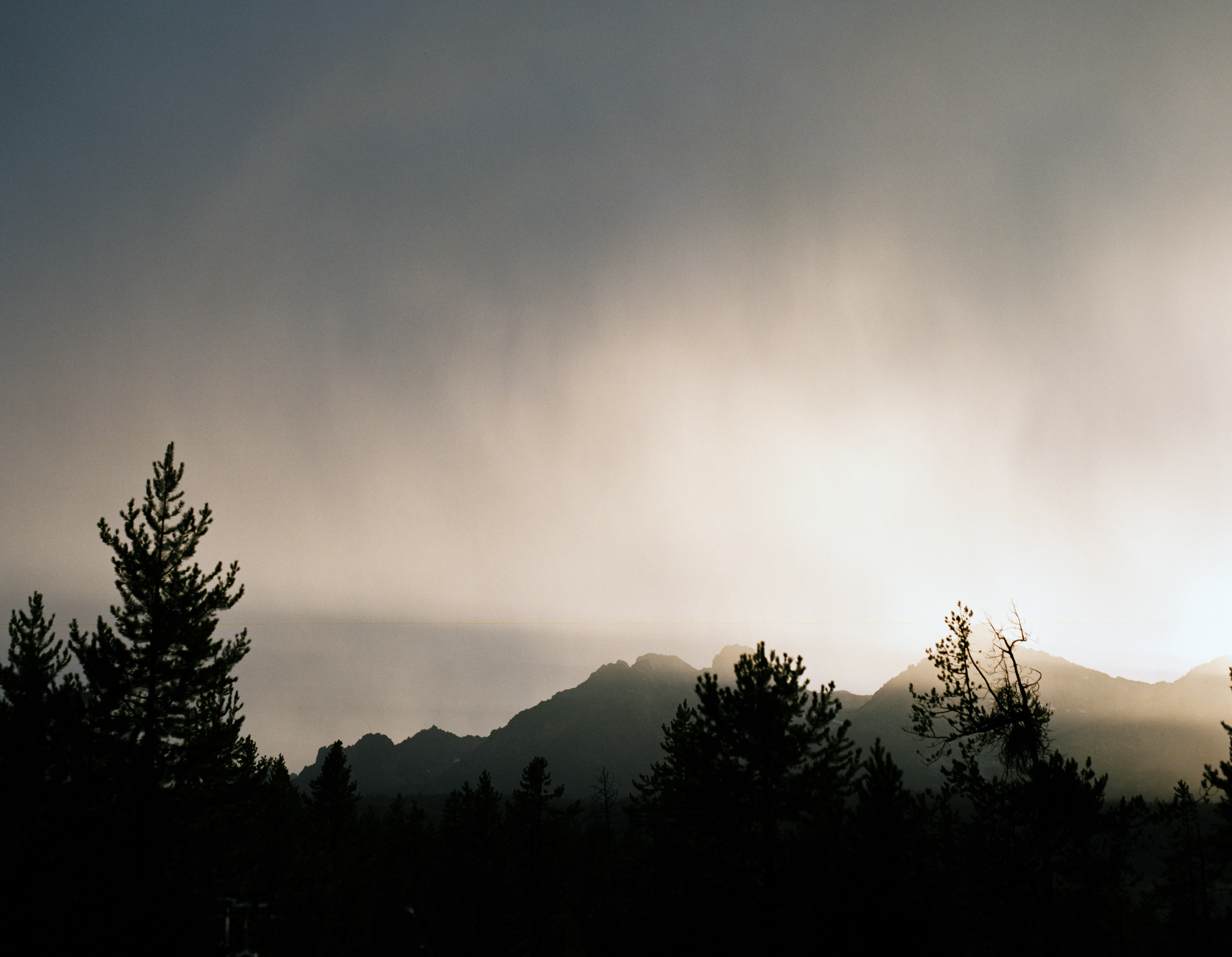 Le soleil brille à travers les nuages au-dessus des montagnes