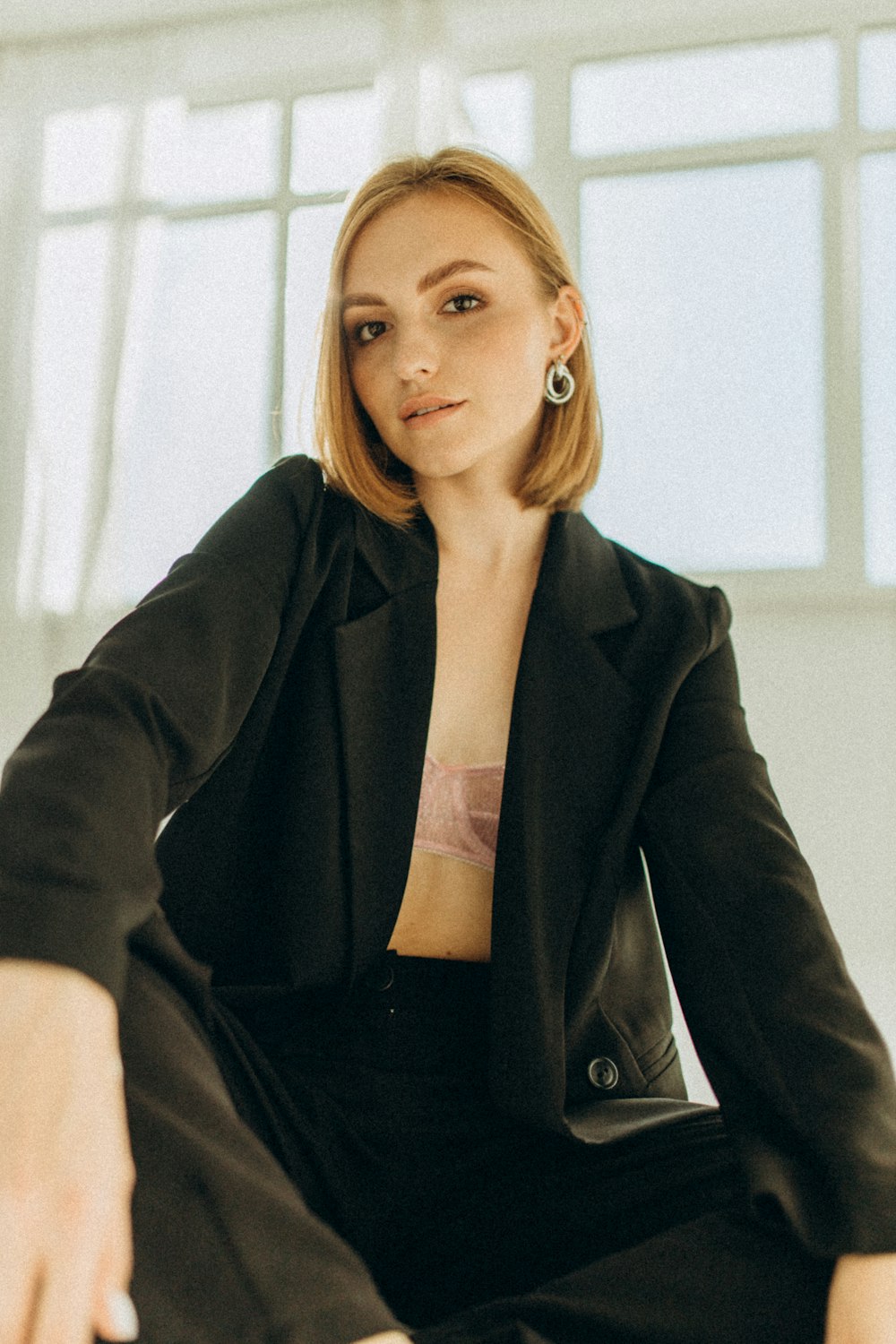 a woman in a black suit sitting on a chair