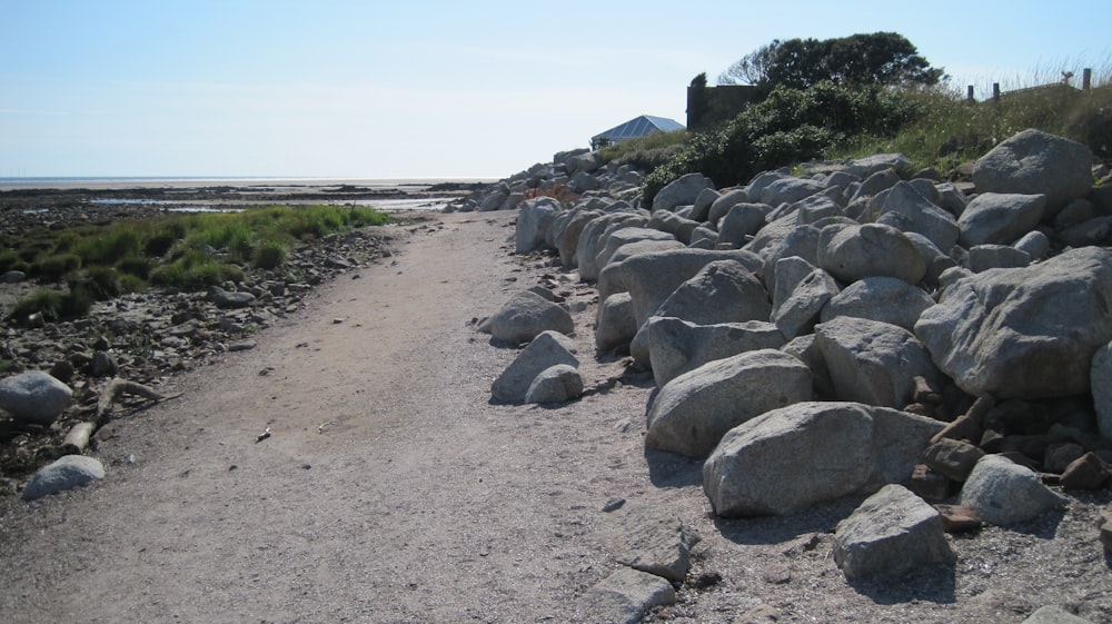 a gravel road with large rocks on the side of it