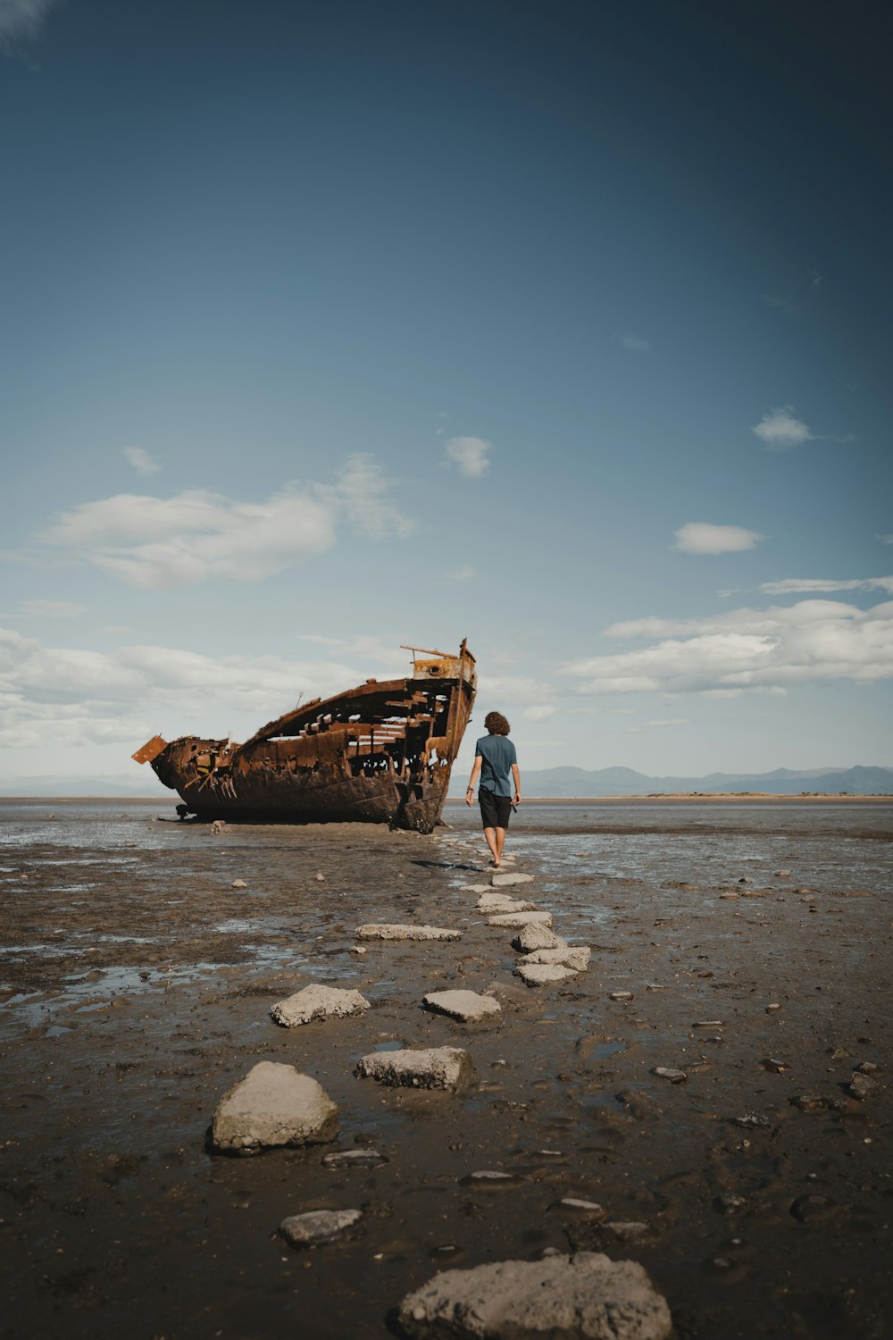 a person standing in front of a boat on the beach